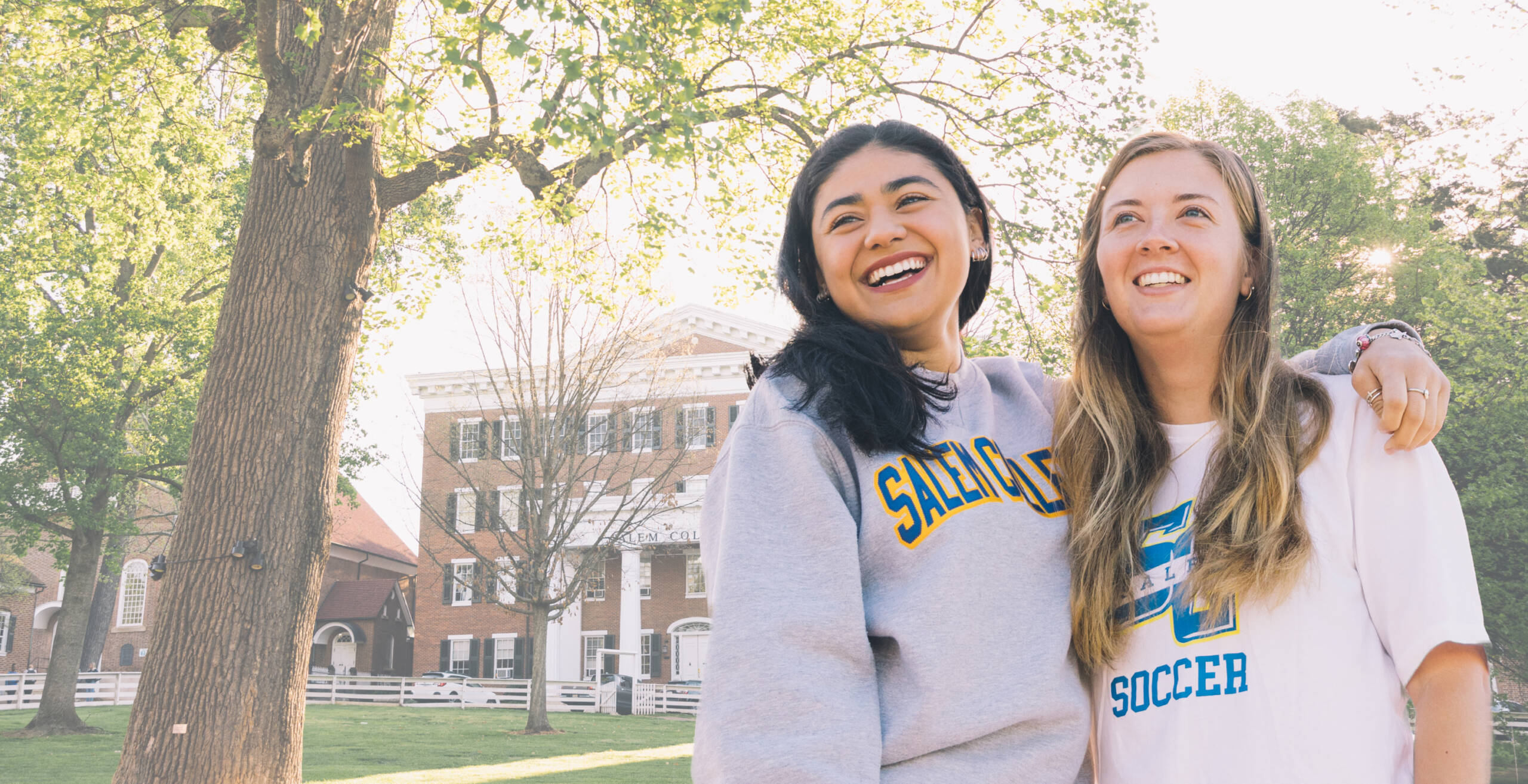 Two 十大买球平台 College students smiling in front of Main hall on campus